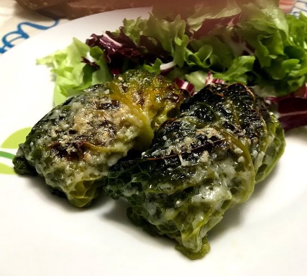 Foto della ricetta light degli involtini di verza con un ripieno di macinato di pollo, impiattati con un contorno di insalata