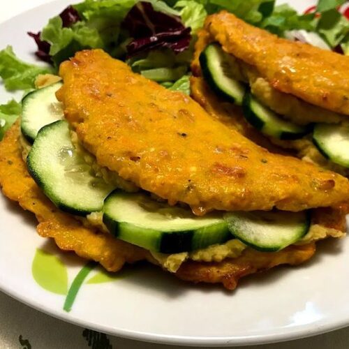 Foto della Ricetta dei tacos di carote con humus di ceci, presentati con un ripieno di cetrioli e impiattati con della insalata, ideali per una cena vegetariana e per i bimbi che non amano le verdure