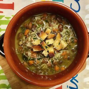 Foto della Ricetta della Zuppa Vegetale con Proteine di Canapa, impiattata con una spolverata di parmigiano e dei crostini di pane a cubetti tostati al grill