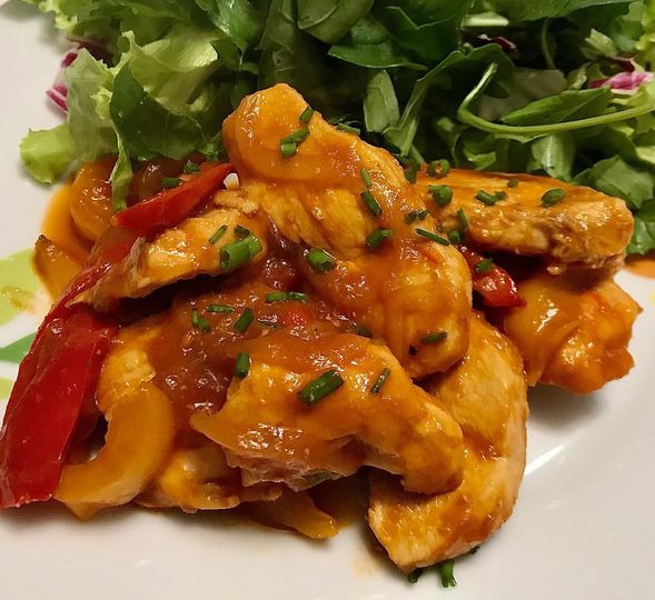 Foto della Ricetta del Pollo ai Peperoni, condito con Zenzero e Cipolla e impiattato con della insalata fresca