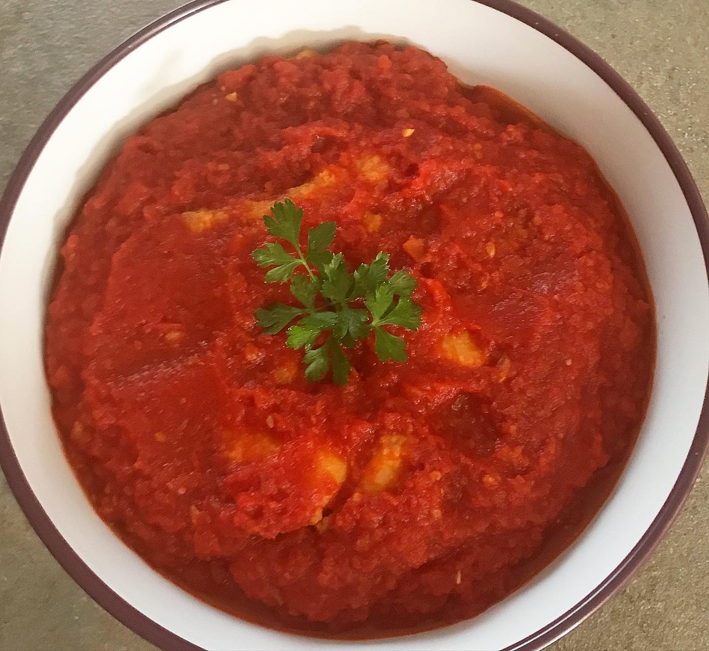 Foto della Ricetta della Agliata di Merluzzo al forno, composta da strati di Merluzzo e Sugo e impiattata con un rametto di Prezzemolo