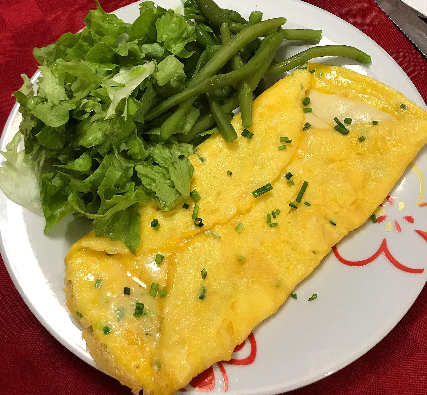 Foto della Ricetta della Omelette al Formaggio, condita con Erba Cipollina, Curcuma e impiattata con della Insalata Fresca