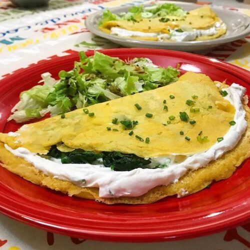 Foto della Ricetta delle Crepes di Ceci farcite con Ricotta Caprina e Spinaci e impiattate con della Insalata Cruda