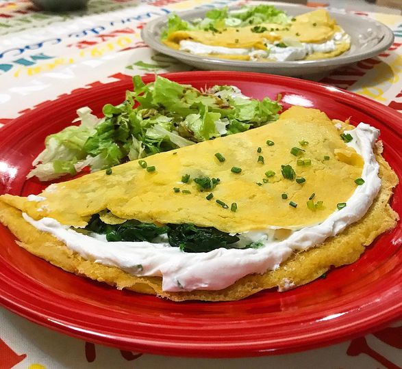 Foto della Ricetta delle Crepes di Ceci farcite con Ricotta Caprina e Spinaci e impiattate con della Insalata Cruda