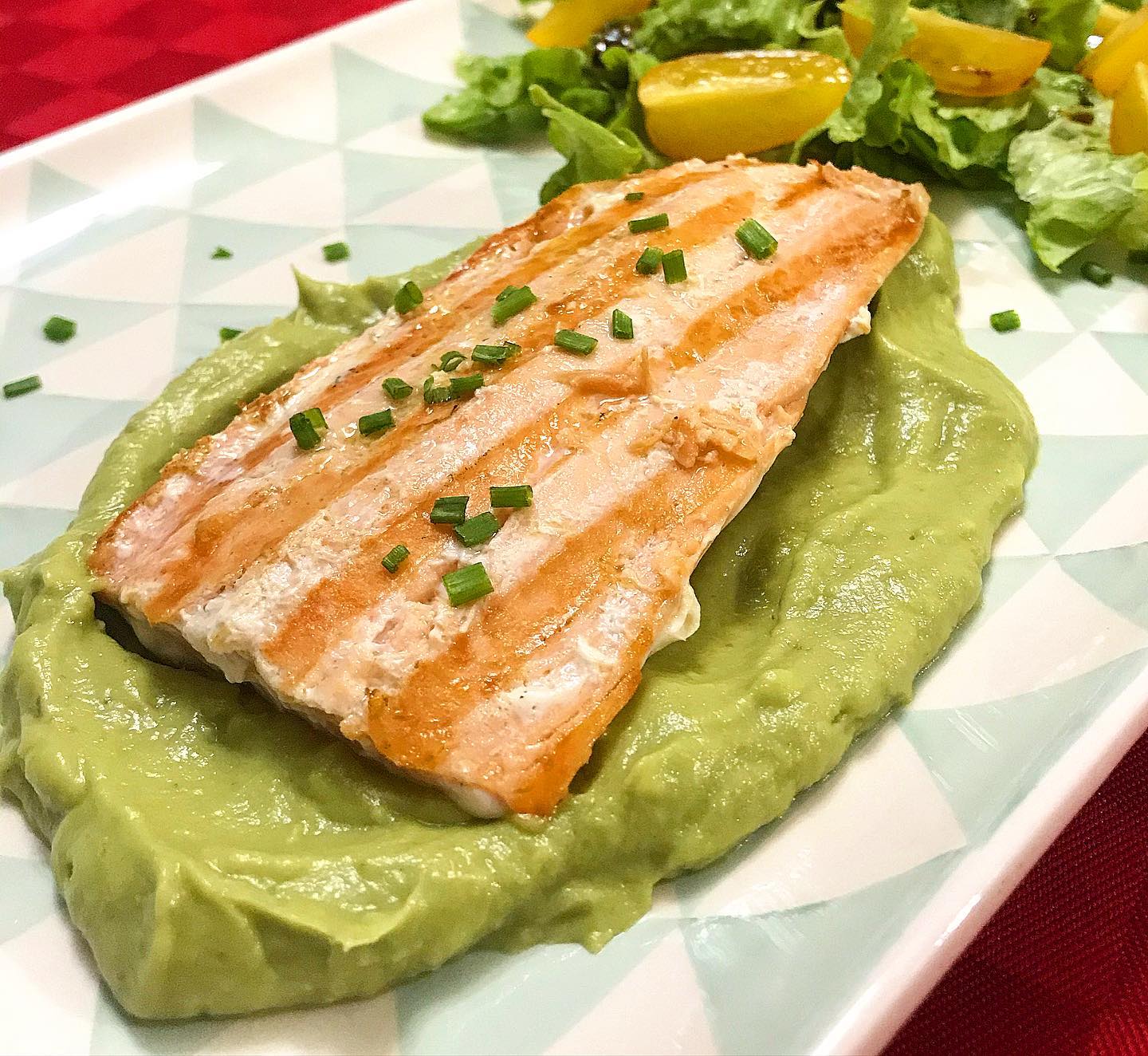 Foto della Ricetta del Filetto di Salmone al Limone con Salsa di Avocado, insaporito con erba cipollina e impiattato con pomodori e insalata cruda