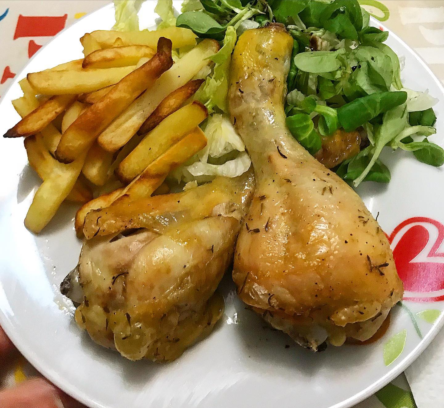 Foto della Ricetta dei Fusi di Pollo al Forno con Aceto di Mele, condito con Spezie quali Coriandolo, Timo, Paprika e impiattato con Patate e Insalata Cruda