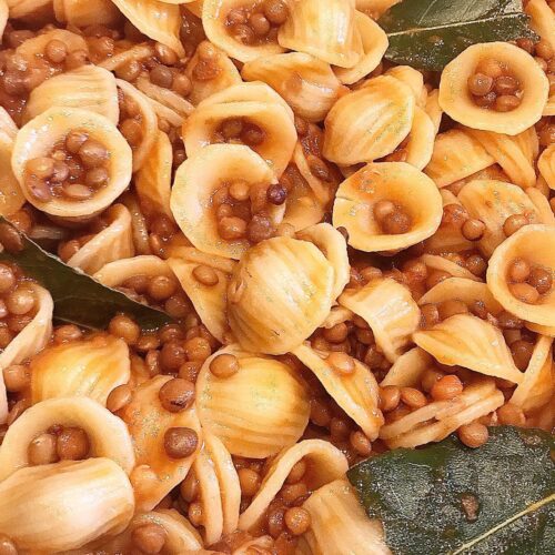 Foto della Ricetta delle Orecchiette con le Lenticchie, condite con qualche goccia di concentrato di pomodoro e impiattate con delle foglie di alloro