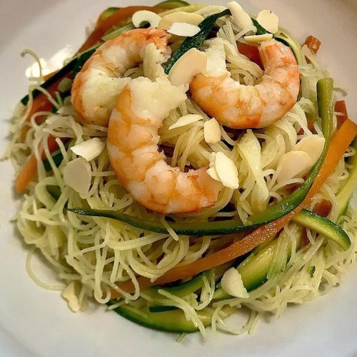 Foto della ricetta dei Noodles di riso con zucchine, carote, salsa di soia, zenzero, mandorle e gamberi.