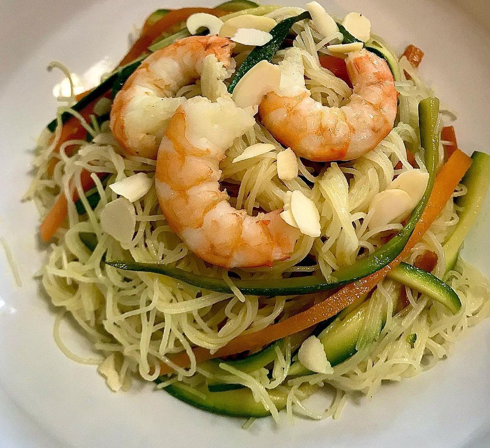 Foto della ricetta dei Noodles di riso con zucchine, carote, salsa di soia, zenzero, mandorle e gamberi.