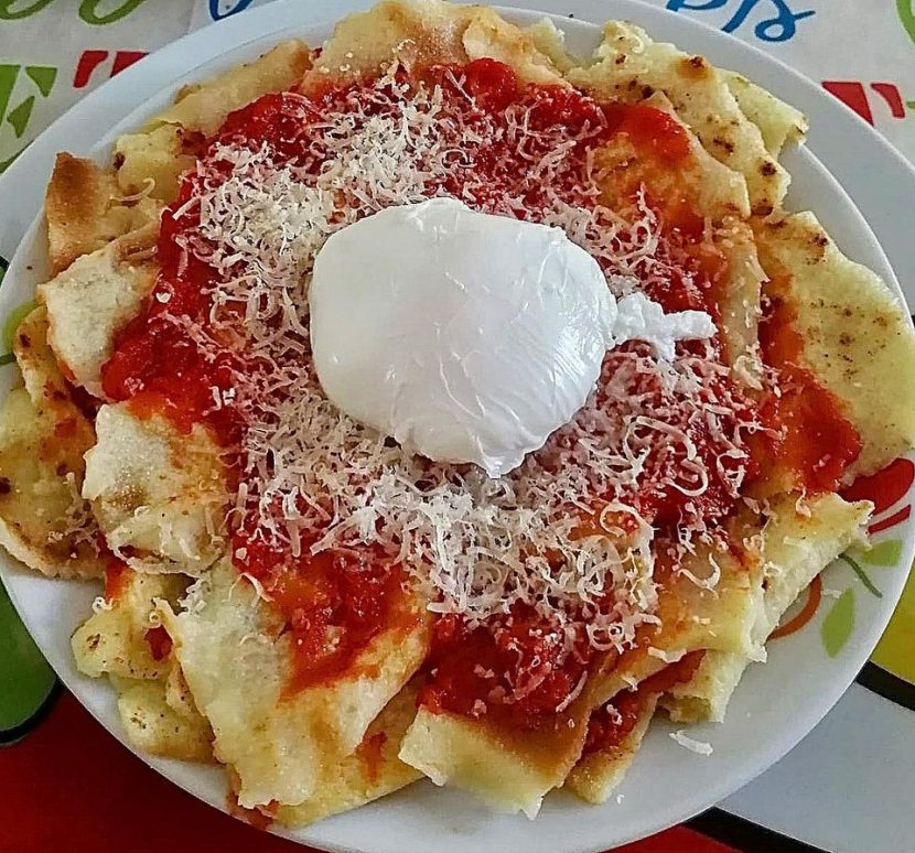 Foto della ricetta di Pai frattau con spicchi di pane carasau, sugo di pomodoro e pecorino sardo.