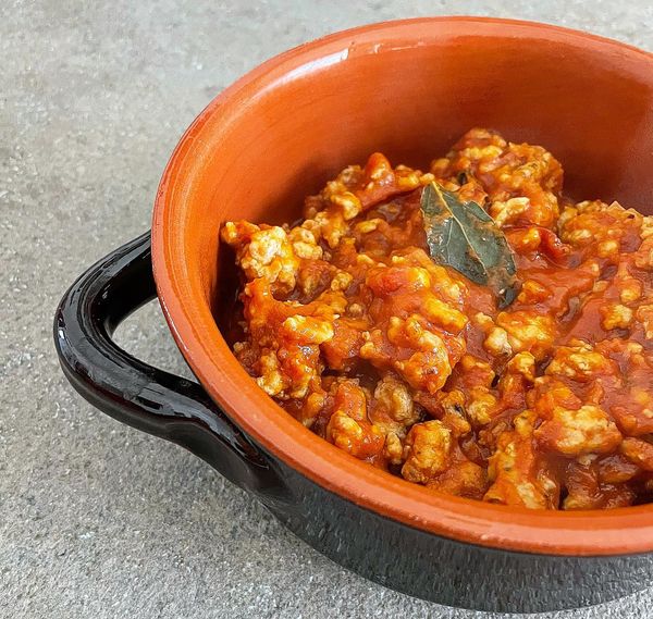 Foto della ricetta di ragù di pollo con passato di pomodoro, cipolla rossa, alloro, timo, salvia, ginepro e vino bianco